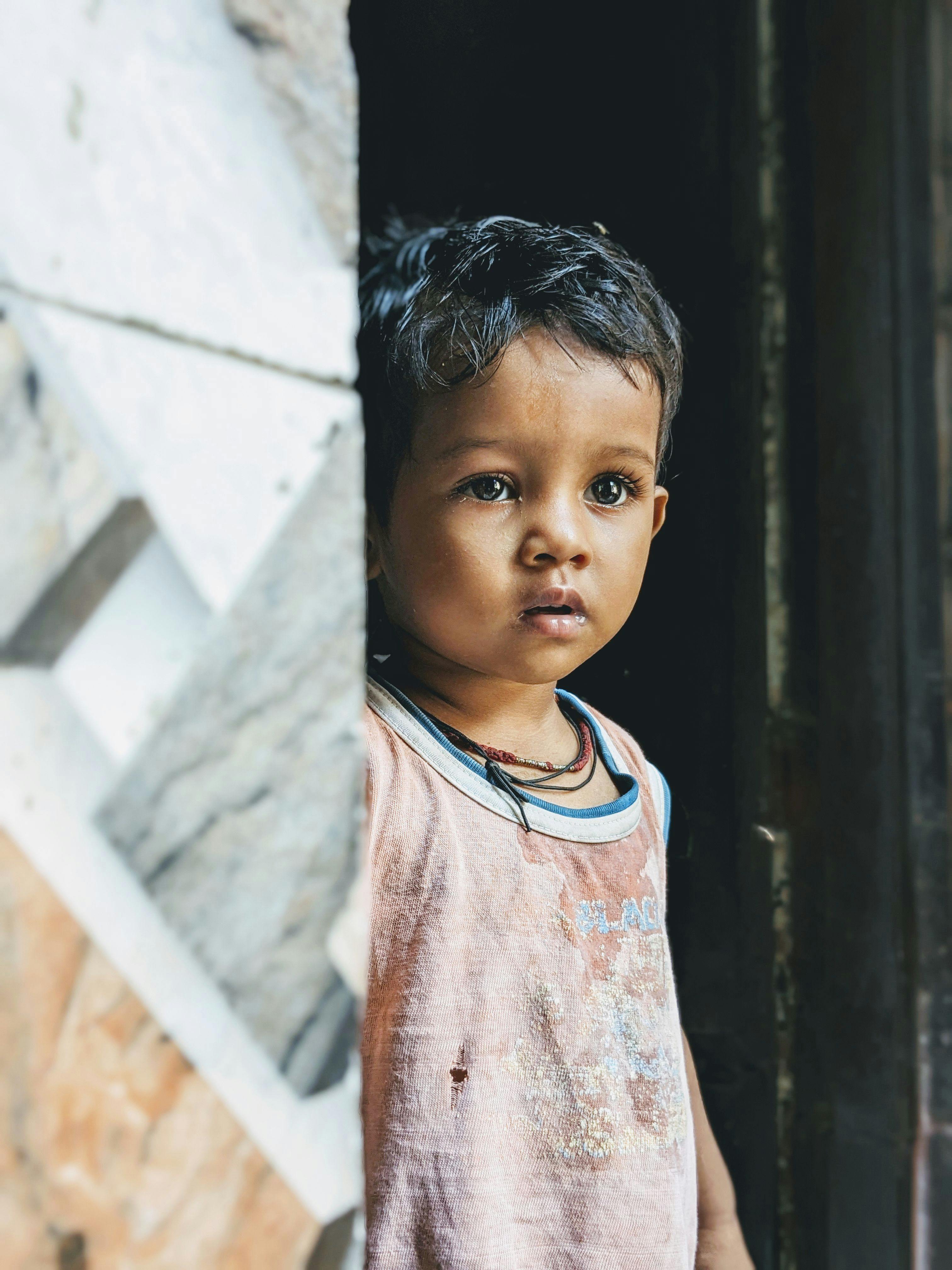 Cute child standing in a doorway, capturing a thoughtful expression.