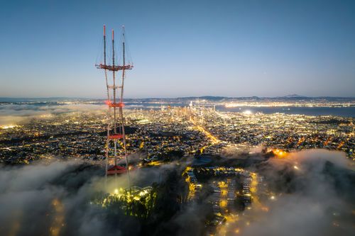 Free Aerial view of San Francisco cityscape with Sutro Tower above fog at twilight, showcasing an urban night scene. Stock Photo