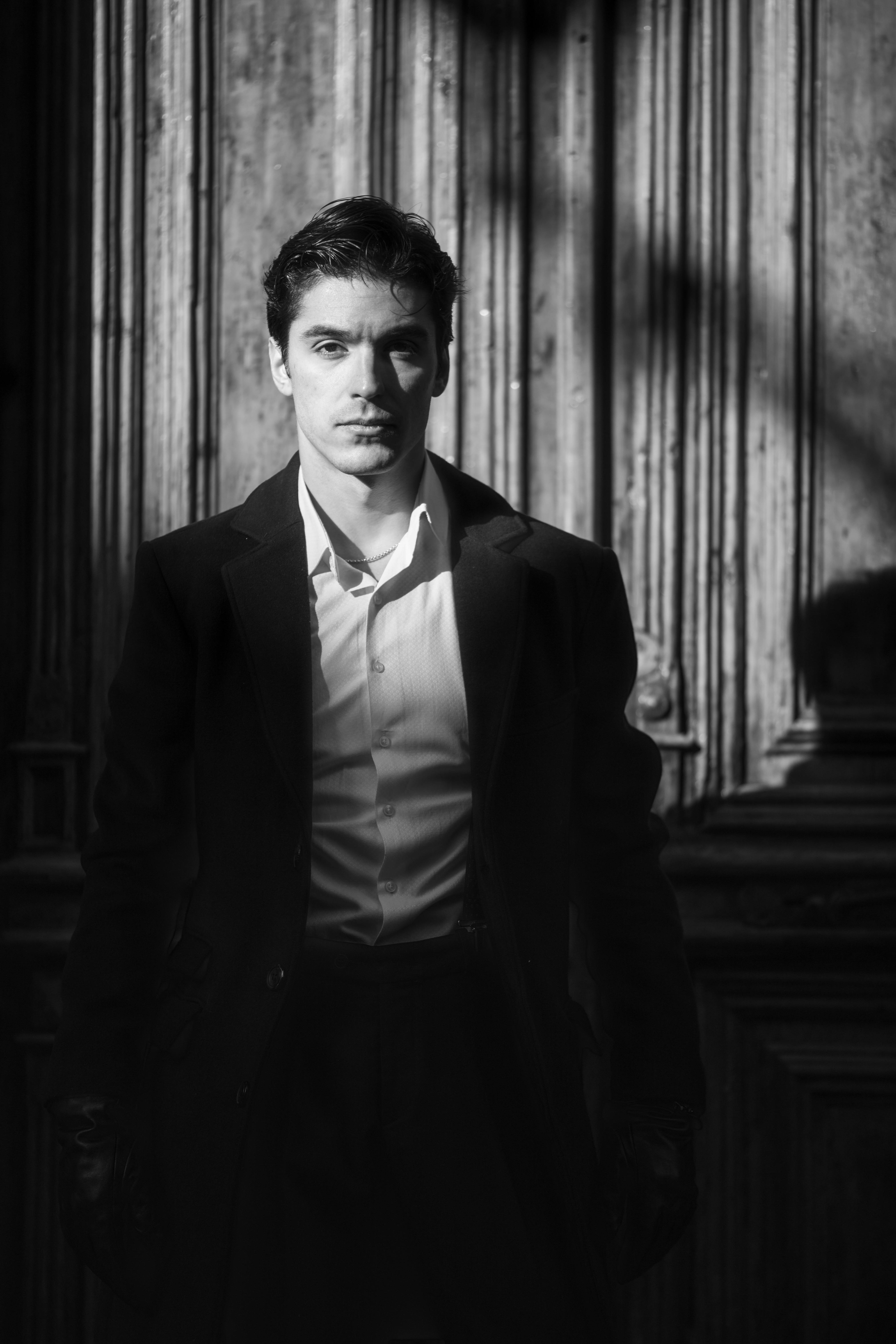 Stylish black and white portrait of a man in a jacket, captured in Baku with dramatic lighting.