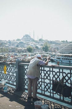在标志性的加拉塔桥上，一个男人正在钓鱼，伊斯坦布尔的天际线清晰可见