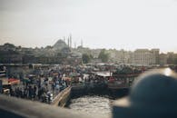 伊斯坦布尔海滨充满活力，人群熙熙攘攘，标志性的清真寺沐浴在日落氛围中