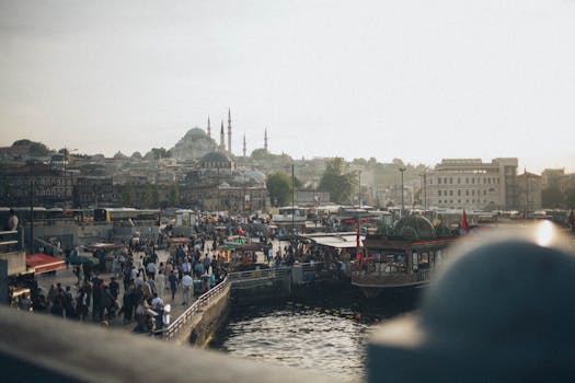 伊斯坦布尔海滨充满活力，人群熙熙攘攘，标志性的清真寺沐浴在日落氛围中