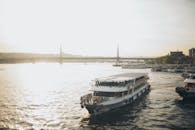 日落时分，一艘渡轮在金角号上巡航，背景中有一座桥