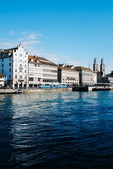 Explore Zurich's iconic riverfront showcasing historic architecture under a clear blue sky.