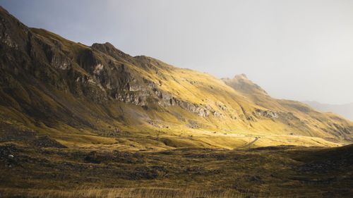 Free Sunlit mountains with rocky valleys create a dramatic and scenic landscape. Stock Photo
