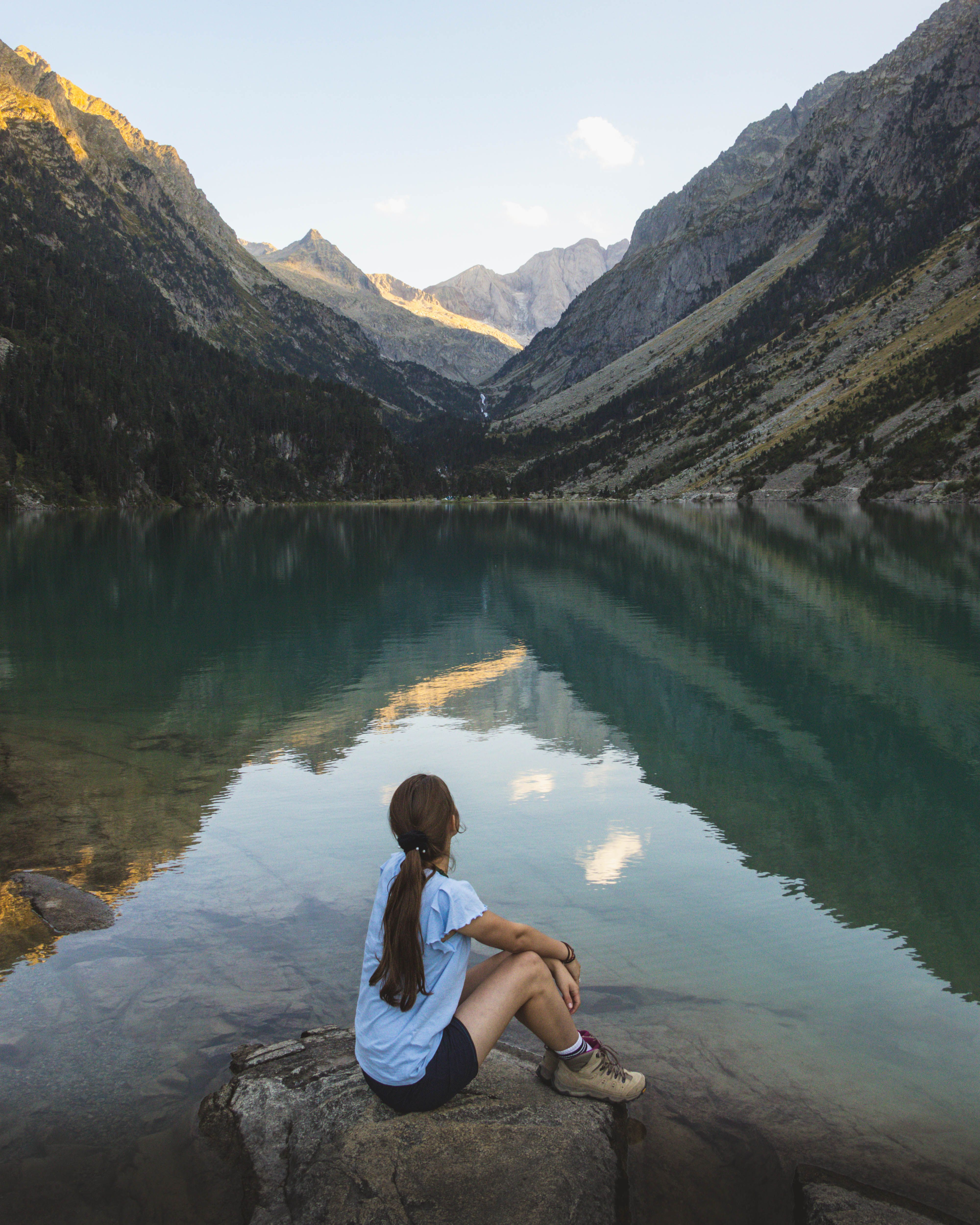 Woman Sitting on a Rock by the Body of Water in Mountains · Free Stock ...
