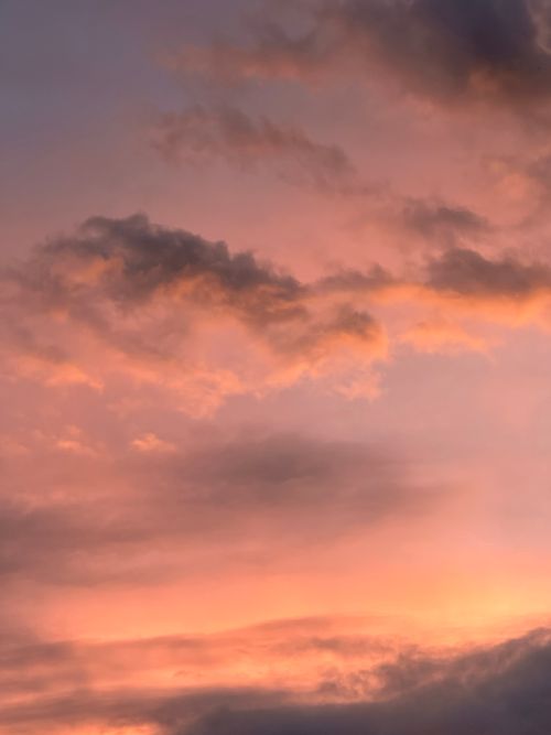 Free Beautiful pink and orange skies at sunset with dramatic cloud formations. Stock Photo