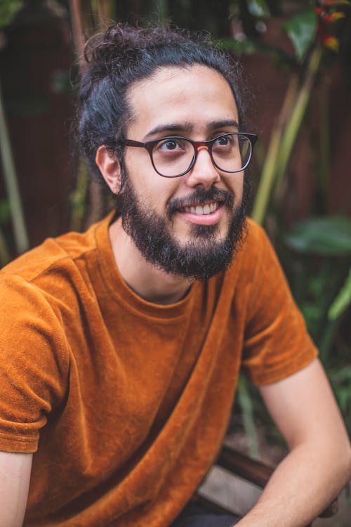 Hombre Sonriente En Camiseta Naranja Con Cuello Redondo Y Anteojos Con Marco Negro