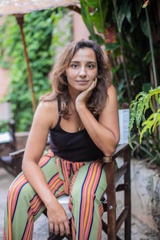 一位时尚女性身着充满活力的条纹裤，在自然环境中摆出户外姿势