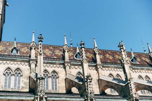 Free Beautiful view of a gothic cathedral roof with intricate details against clear blue sky. Stock Photo