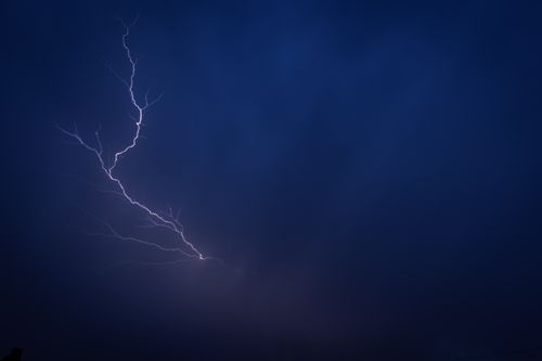 Free Dramatic lightning bolt illuminating a dark stormy sky at night. Stock Photo