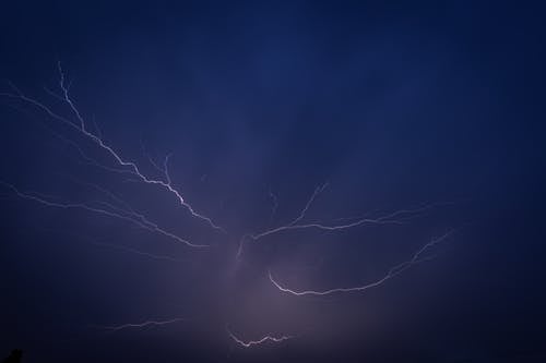 Lightning strikes over the ocean in the dark