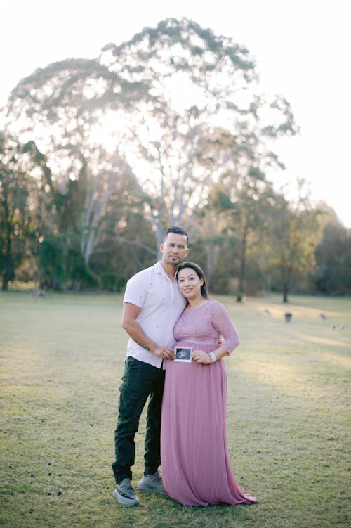 A Couple Posing Outside at a Pregnancy Photoshoot