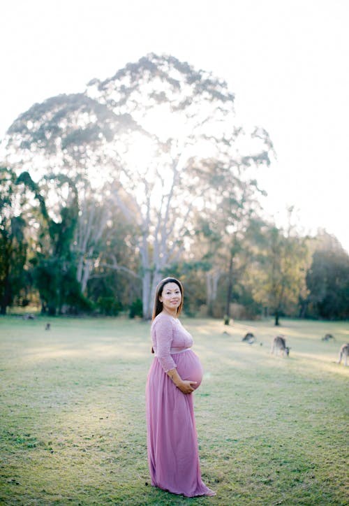 Pregnant Woman Posing Outside and Touching Her Stomach 