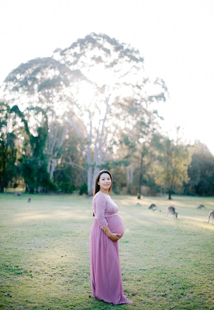 Pregnant Woman Posing Outside And Touching Her Stomach 