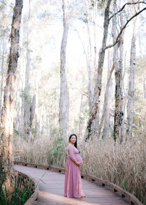 Pregnant Woman Posing Outside and Touching Her Stomach 