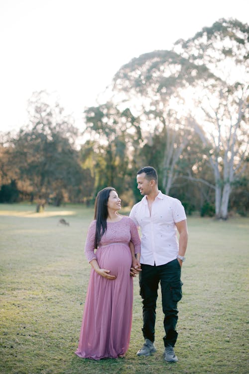 A Couple Posing Outside at a Pregnancy Photoshoot