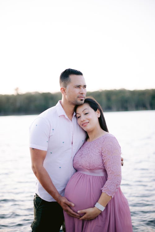 Man Hugging His Pregnant Wife by the Lake