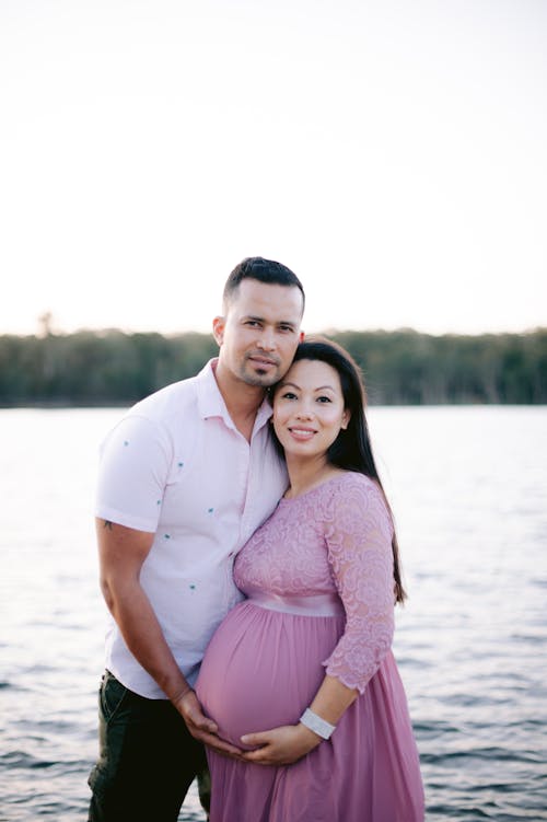 A Couple Posing Outside at a Pregnancy Photoshoot