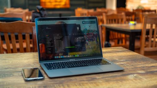 Free Laptop and smartphone on a wooden table in a cozy café setting in Ankara, Turkey. Stock Photo