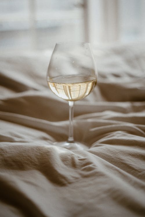 Drink in Glass on Bedclothes