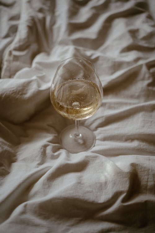 Glass of Champagne on White Sheet