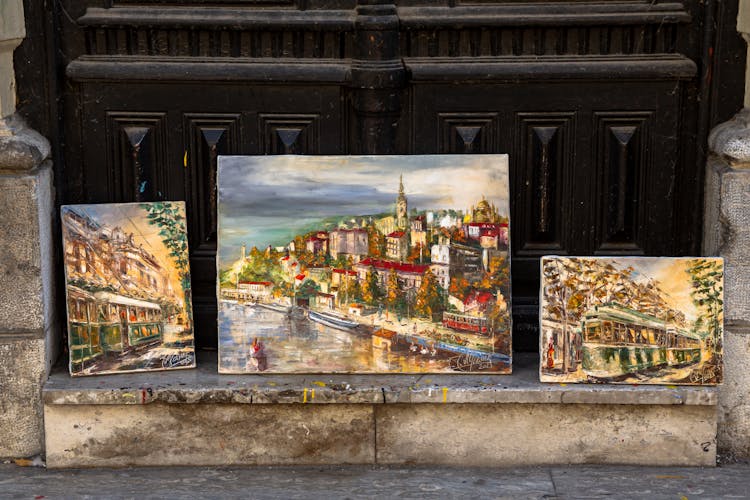 Paintings Of Trams And Town On Sidewalk