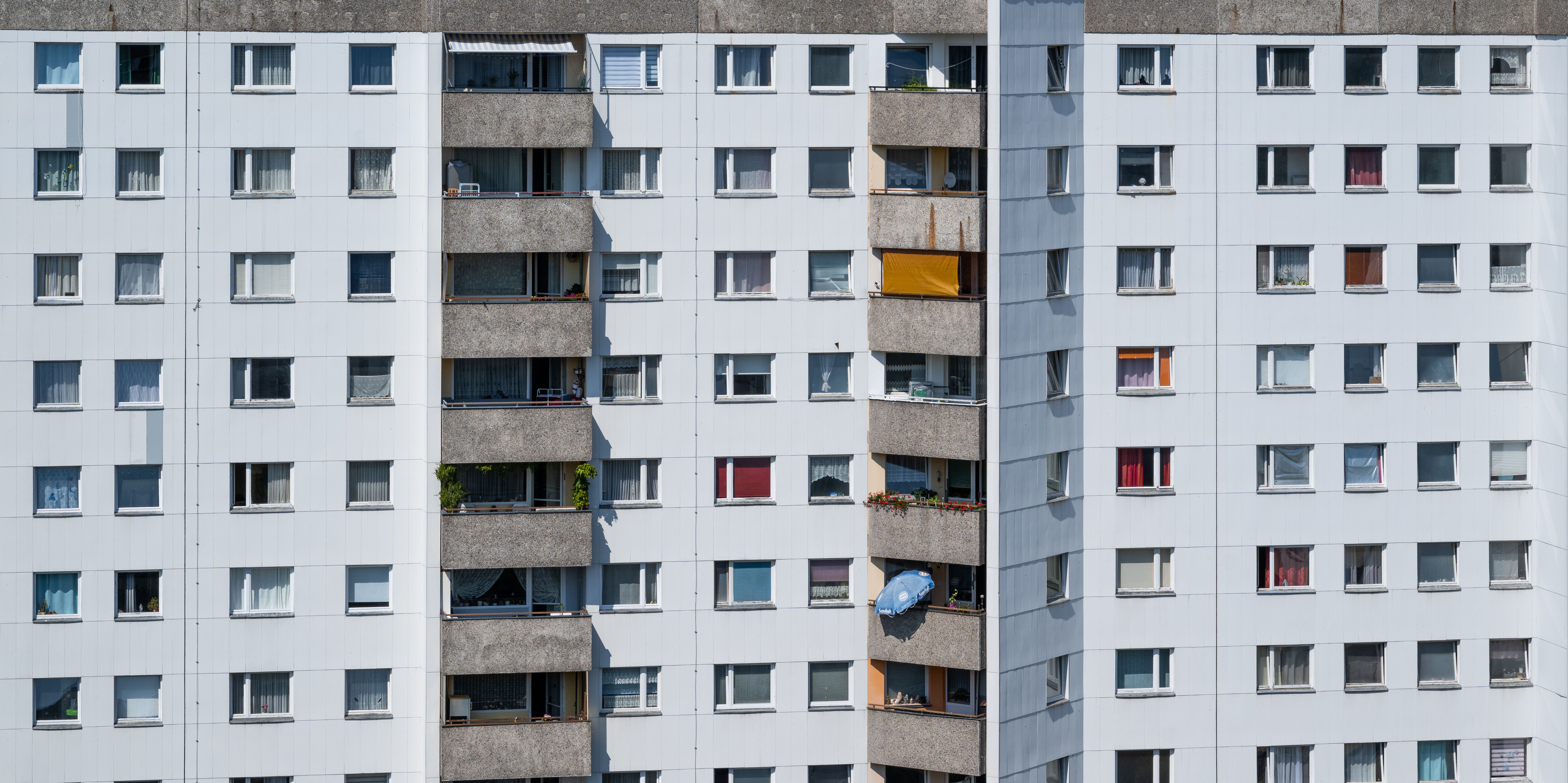 Modern bir apartman bloğunun balkonları ve pencereleri içeren dış cephesi.