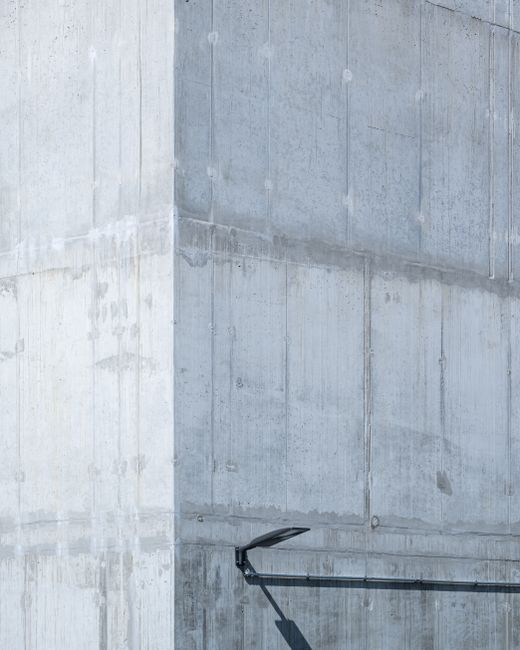 Stark concrete wall exterior with shadow play in Berlin, capturing urban minimalism.