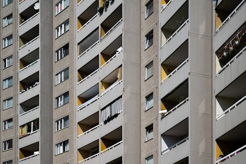 A building with balconies and windows with yellow and white stripes