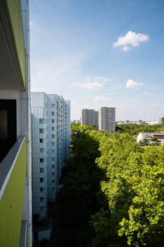 High-rise buildings surrounded by greenery under a clear blue sky in Berlin.