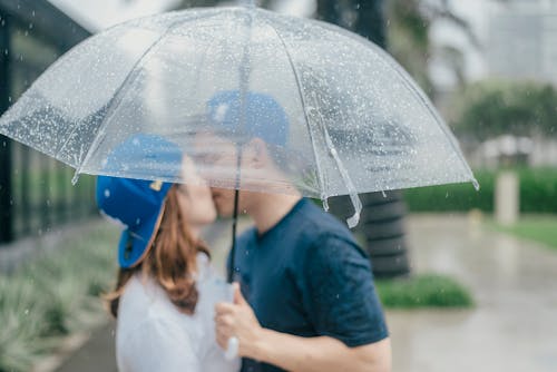 우산 아래 키스하는 커플