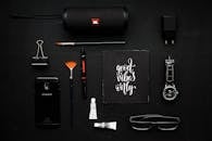 黑暗表面上平躺的现代小工具和艺术用品，传达出一种风格与灵感的情绪