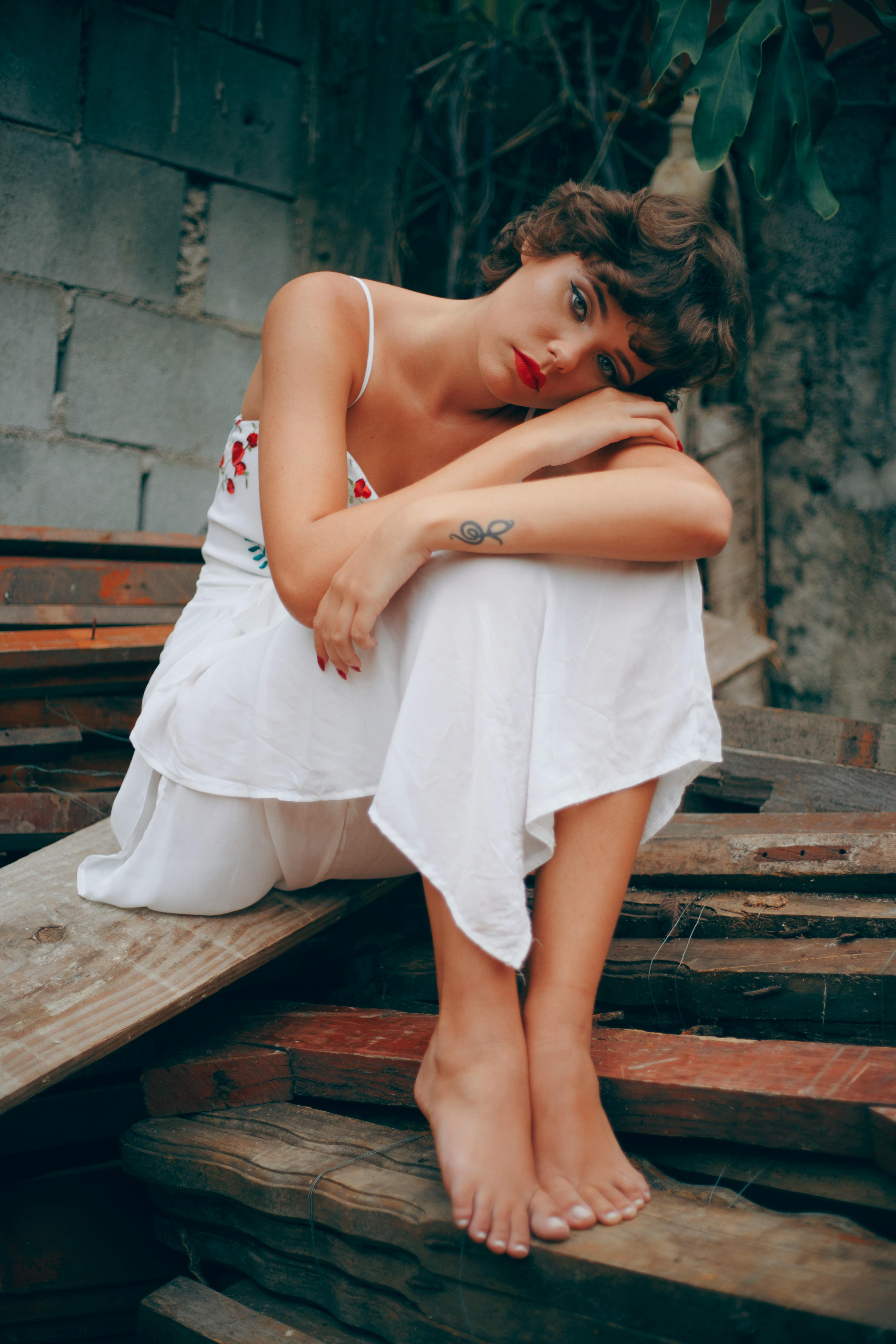 woman sitting on pile of wood