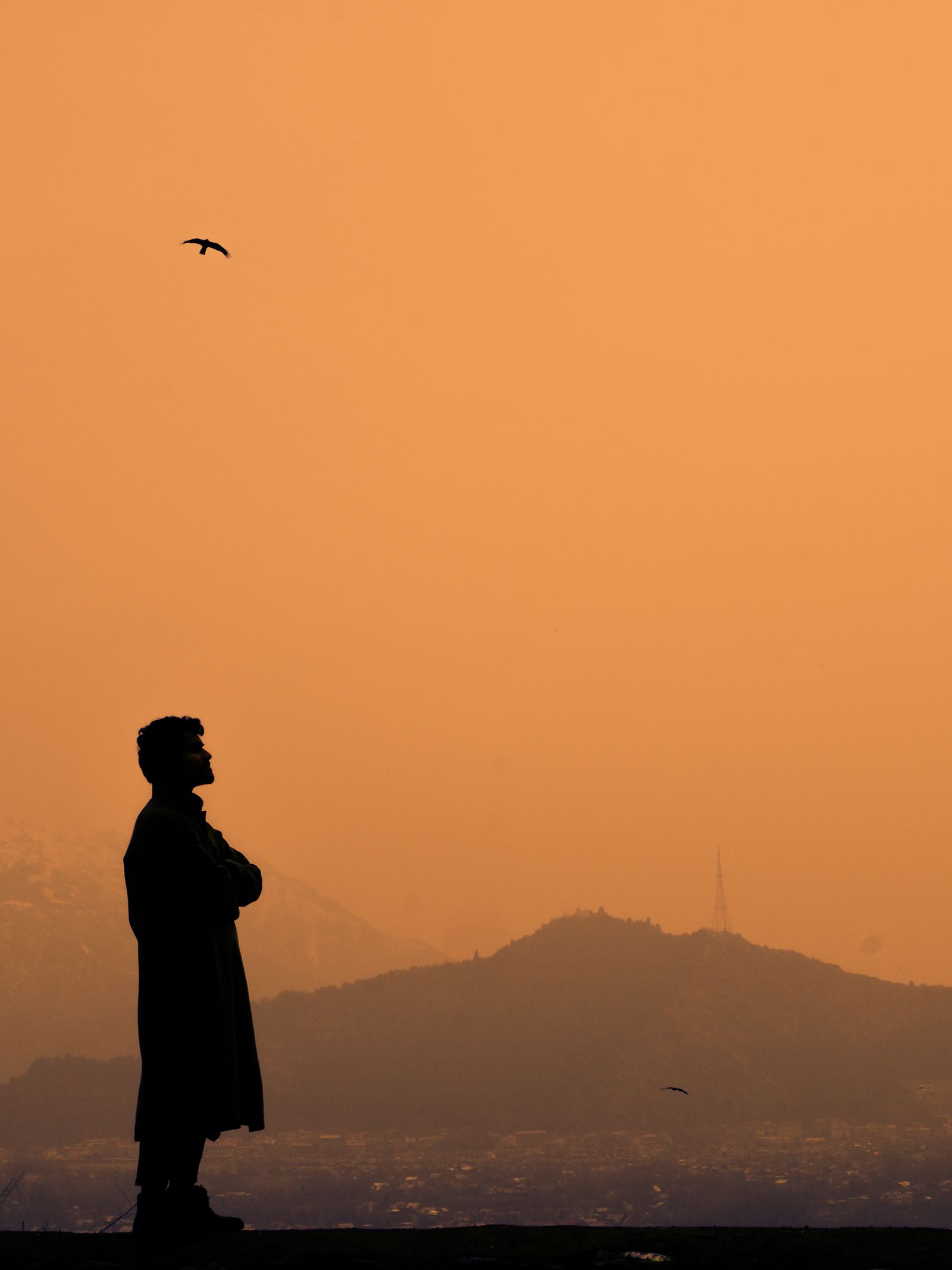 Silhueta de homem sozinho ao pôr do sol, refletindo