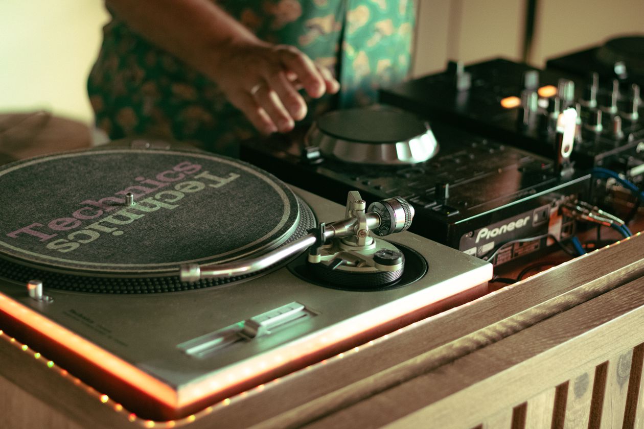 A DJ mixing music on turntables at an event