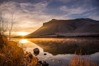 宁静的湖泊倒映着雄伟的山影，映衬着令人叹为观止的日出