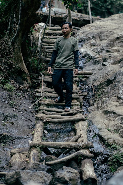 Young Man Walking on a Wooden Trail 