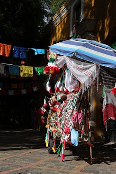 Vibrant Mexican market stand adorned with colorful traditional decorations and hanging flags.