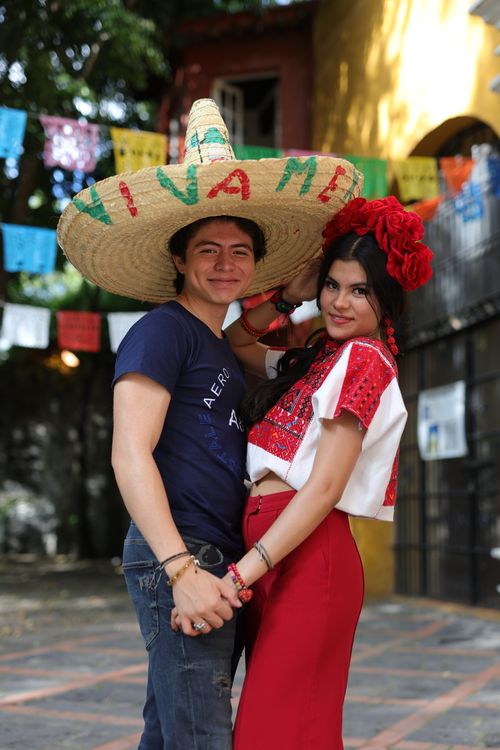 Free Joyful couple celebrating Mexican culture outdoors in vibrant traditional costumes. Stock Photo