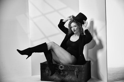 Woman Wearing Fishnets and Boots Posing in Studio