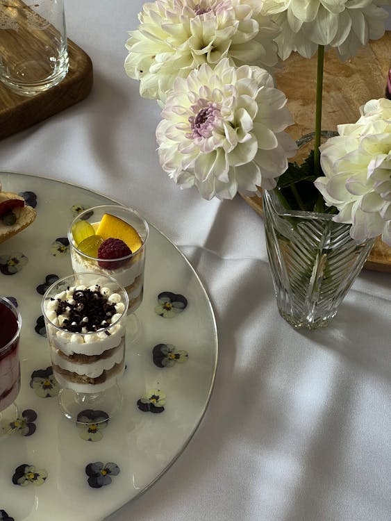 Ice Creams in Glasses by Dahlias in Vase on Table