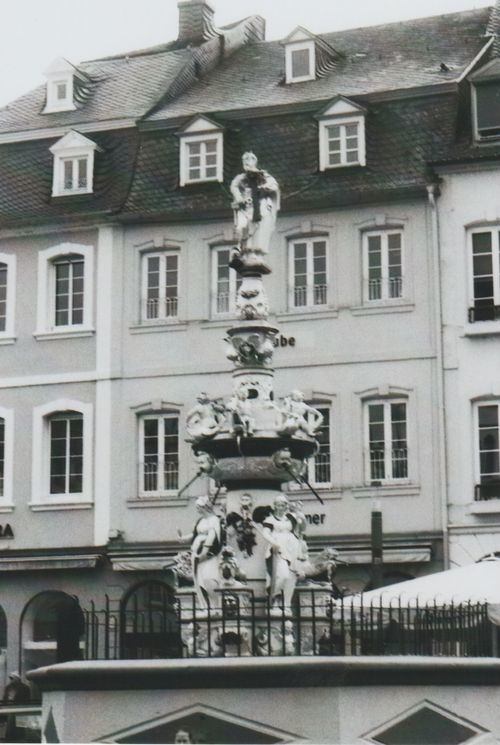 Free A classic sculpture fountain in a historic city square, captured in monochrome. Stock Photo