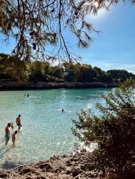 Serene beach with turquoise waters in Cala d'Or, Spain, perfect for a summer retreat.
