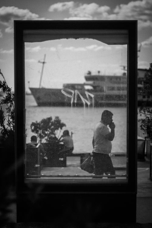 Free Black and white photo capturing the reflection of a man by Kadıköy harbor in Istanbul. Stock Photo