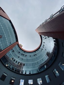 View of a modern curved office building facade in an urban area of KL, India.