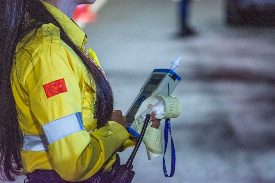 A security officer in yellow uniform holding a device during nighttime in Londrina, Brazil.
