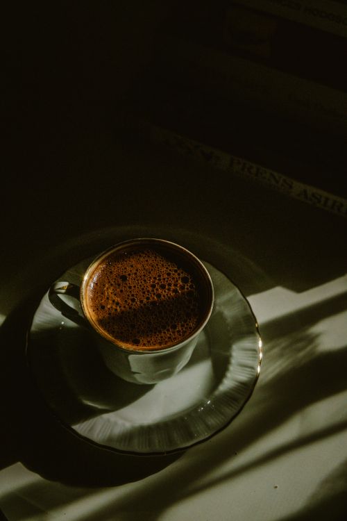Free A cup of coffee casting dramatic shadows with a minimalist still life composition. Stock Photo