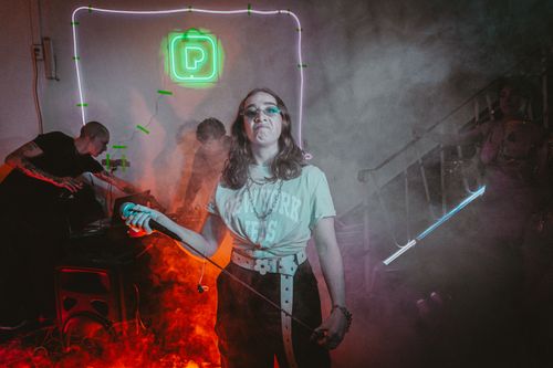 Free Dynamic scene of a female performer in a club surrounded by vibrant lights and smoke. Stock Photo