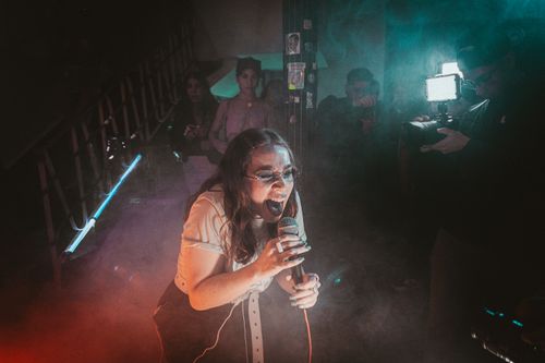 Free An intense performance by a female singer at an intimate club concert, capturing high energy and passion. Stock Photo